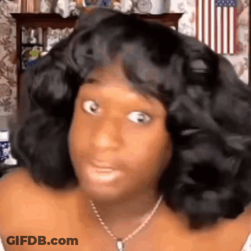 A Woman With A Wig On Her Head Is Making A Funny Face . GIF