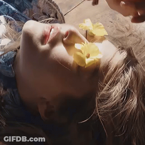 A Woman With A Yellow Flower In Her Hair GIF