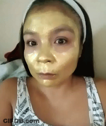 A Woman With A Yellow Mask On Her Face Looks At The Camera GIF