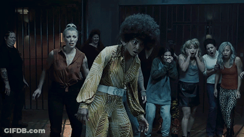 A Woman With An Afro Stands In Front Of A Crowd Of Women GIF