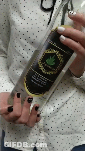 A Woman With Black Nails Holds A Bottle Of Alcohol GIF
