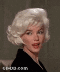 A Woman With Blonde Hair And A Black Jacket Is Making A Face . GIF