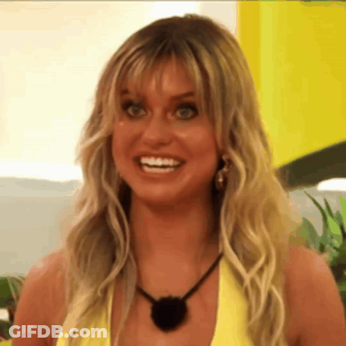 A Woman With Blonde Hair And A Black Necklace Is Smiling GIF