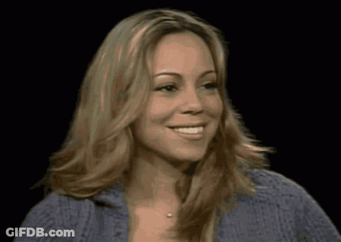 A Woman With Blonde Hair And A Blue Sweater Smiles GIF