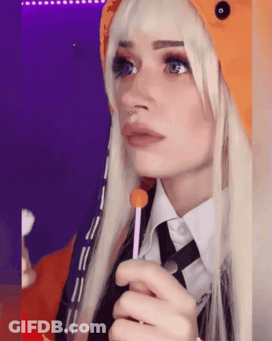 A Woman With Blonde Hair And A Nose Ring Holds A Lollipop In Her Hand GIF