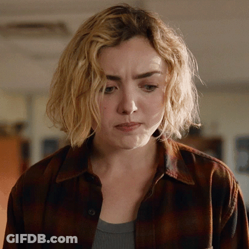 A Woman With Blonde Hair And A Plaid Shirt Looks Sad GIF