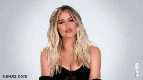 A Woman With Blonde Hair And A Plunging Neckline Is Wearing A Black Dress . GIF