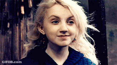 A Woman With Blonde Hair And Blue Eyes Is Smiling And Wearing A Blue Sweater . GIF