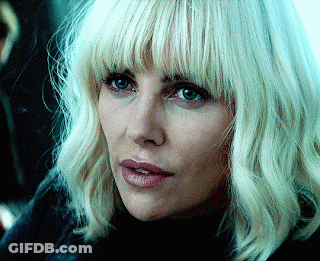 A Woman With Blonde Hair And Blue Eyes Is Wearing A Black Turtleneck GIF