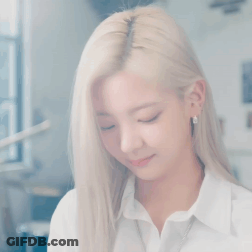 A Woman With Blonde Hair And Blue Eyes Is Wearing A White Shirt . GIF