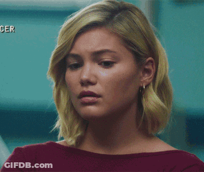 A Woman With Blonde Hair And Earrings Is Wearing A Red Shirt GIF