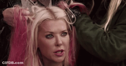 A Woman With Blonde Hair And Pink Highlights Is Getting Her Hair Dyed . GIF