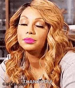 A Woman With Blonde Hair And Pink Lipstick Is Making A Funny Face . GIF