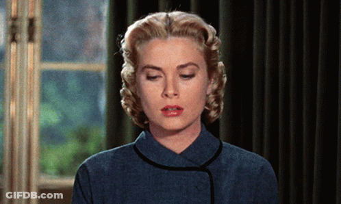 A Woman With Blonde Hair And Red Lips Is Wearing A Blue Shirt GIF
