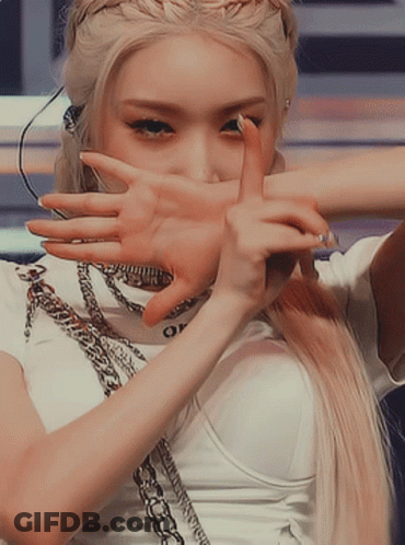 A Woman With Blonde Hair Is Covering Her Face With Her Hand GIF