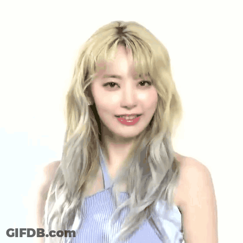 A Woman With Blonde Hair Is Covering Her Nose In Front Of A White Background With Korean Writing GIF