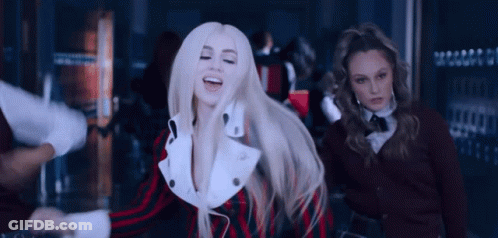 A Woman With Blonde Hair Is Dancing In A Crowded Room While Two Other Women Look On . GIF