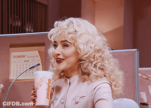 A Woman With Blonde Hair Is Drinking From A Dunkin Donuts Cup GIF