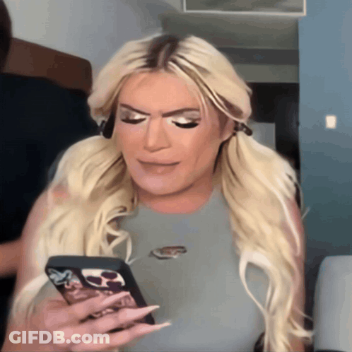 A Woman With Blonde Hair Is Holding A Cell Phone With A Case That Says Nike On It GIF