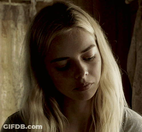 A Woman With Blonde Hair Is Looking Down At Something GIF