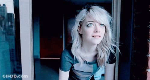 A Woman With Blonde Hair Is Looking Out Of A Window GIF