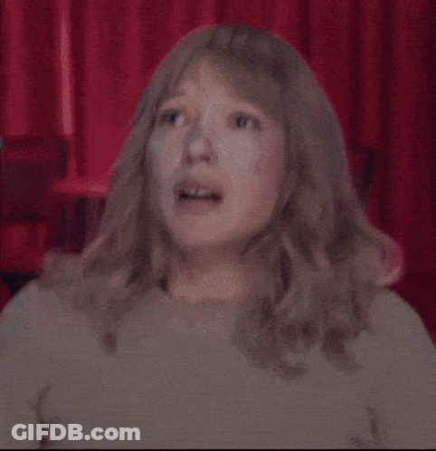 A Woman With Blonde Hair Is Making A Funny Face GIF