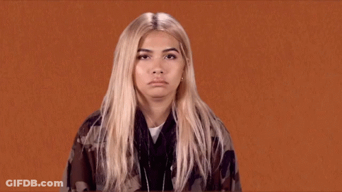 A Woman With Blonde Hair Is Making A Funny Face . GIF