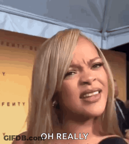 A Woman With Blonde Hair Is Making A Funny Face While Talking Into A Microphone . GIF