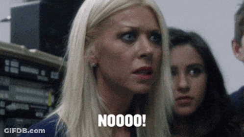 A Woman With Blonde Hair Is Saying Noooo In Front Of A Group Of People . GIF