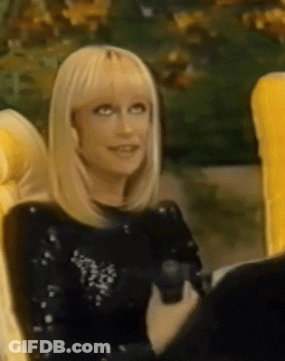 A Woman With Blonde Hair Is Sitting In A Chair GIF