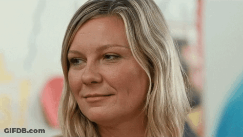 A Woman With Blonde Hair Is Smiling For The Camera GIF