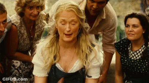 A Woman With Blonde Hair Is Surrounded By A Group Of People GIF