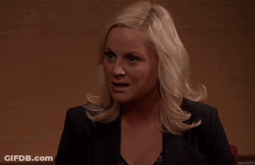 A Woman With Blonde Hair Is Wearing A Black Jacket And A Black Top GIF