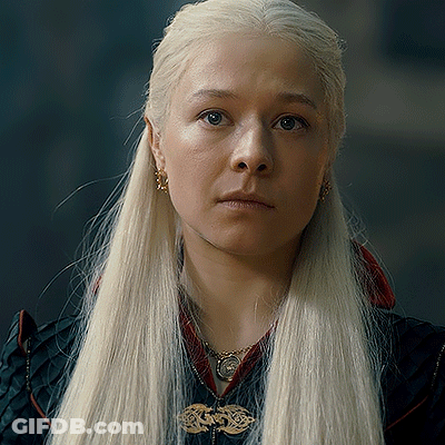 A Woman With Blonde Hair Is Wearing A Black Jacket And A Necklace GIF