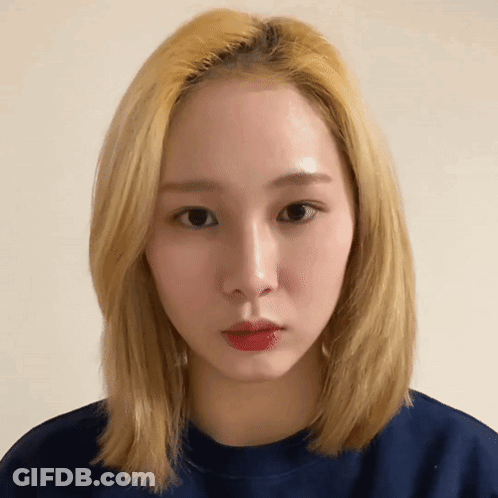 A Woman With Blonde Hair Is Wearing A Blue Sweater GIF