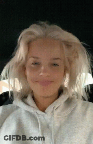A Woman With Blonde Hair Is Wearing A Gray Hoodie GIF