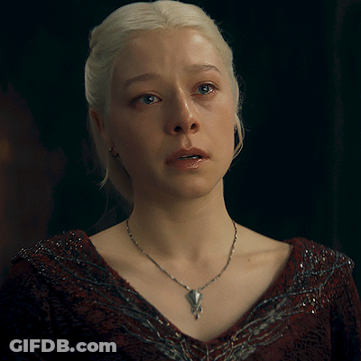A Woman With Blonde Hair Is Wearing A Necklace With A Pendant GIF