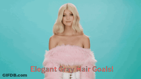A Woman With Blonde Hair Is Wearing A Pink Fur Coat GIF