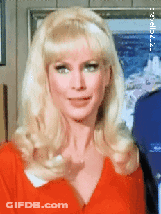 A Woman With Blonde Hair Is Wearing A Red Shirt And A Headband .. GIF