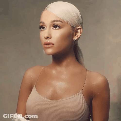 A Woman With Blonde Hair Is Wearing A Tank Top GIF