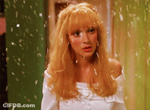 A Woman With Blonde Hair Is Wearing A White Top GIF