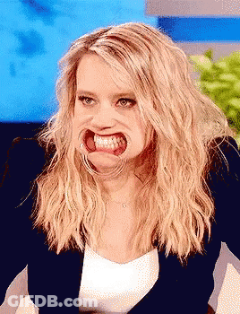 A Woman With Blonde Hair Making A Funny Face With Her Mouth Open GIF