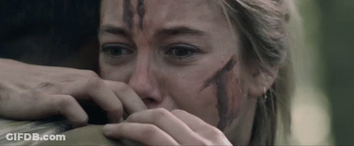 A Woman With Blood On Her Face Is Holding A Man 'S Arm GIF