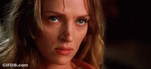 A Woman With Blood On Her Face Is Looking At The Camera . GIF