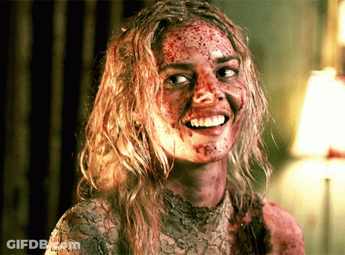 A Woman With Blood On Her Face Is Smiling And Looking At The Camera GIF