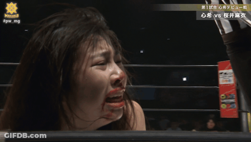 A Woman With Blood On Her Face Is Standing In A Wrestling Ring With The Hashtag #Pw_mg On The Bottom GIF
