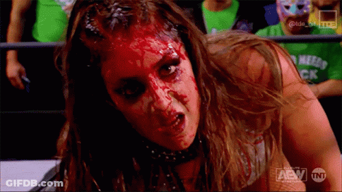 A Woman With Blood On Her Face Is Wearing A Shirt That Says Tnt On It GIF