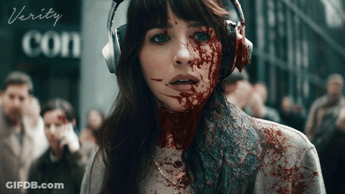 A Woman With Blood On Her Face Is Wearing Headphones And The Word Verity Is On The Bottom GIF