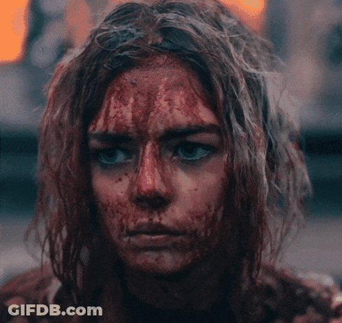 A Woman With Blood On Her Face Looking At The Camera GIF