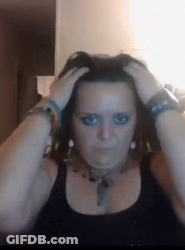 A Woman With Blue Eye Makeup Is Holding Her Head GIF